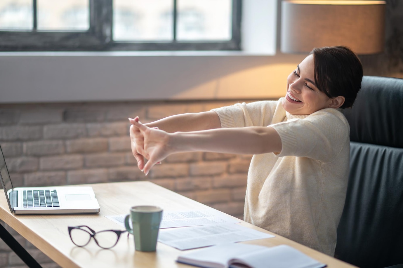 pleased-female-doing-wrist-stretches-desk_259150-60501